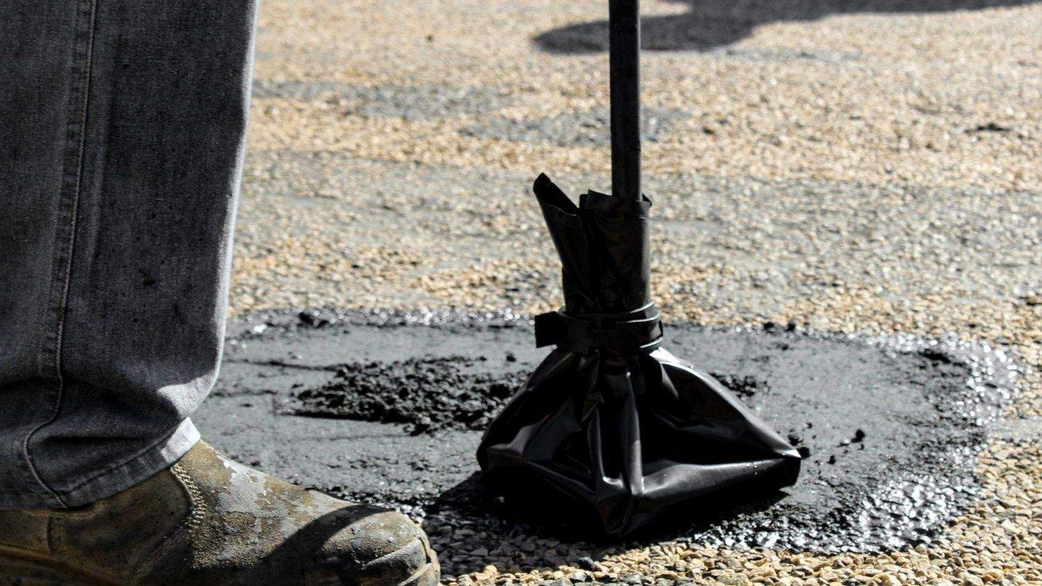 pothole repair crew working in retail parking lot