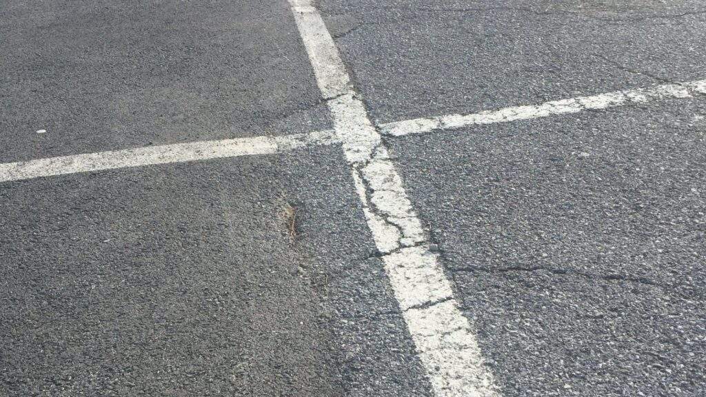 cracked pavement at retail parking lot entrance